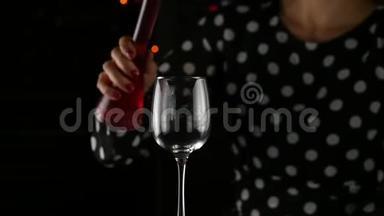 红酒灌杯.. 女人在黑暗中喝一杯红酒。 节日气氛。 慢动作